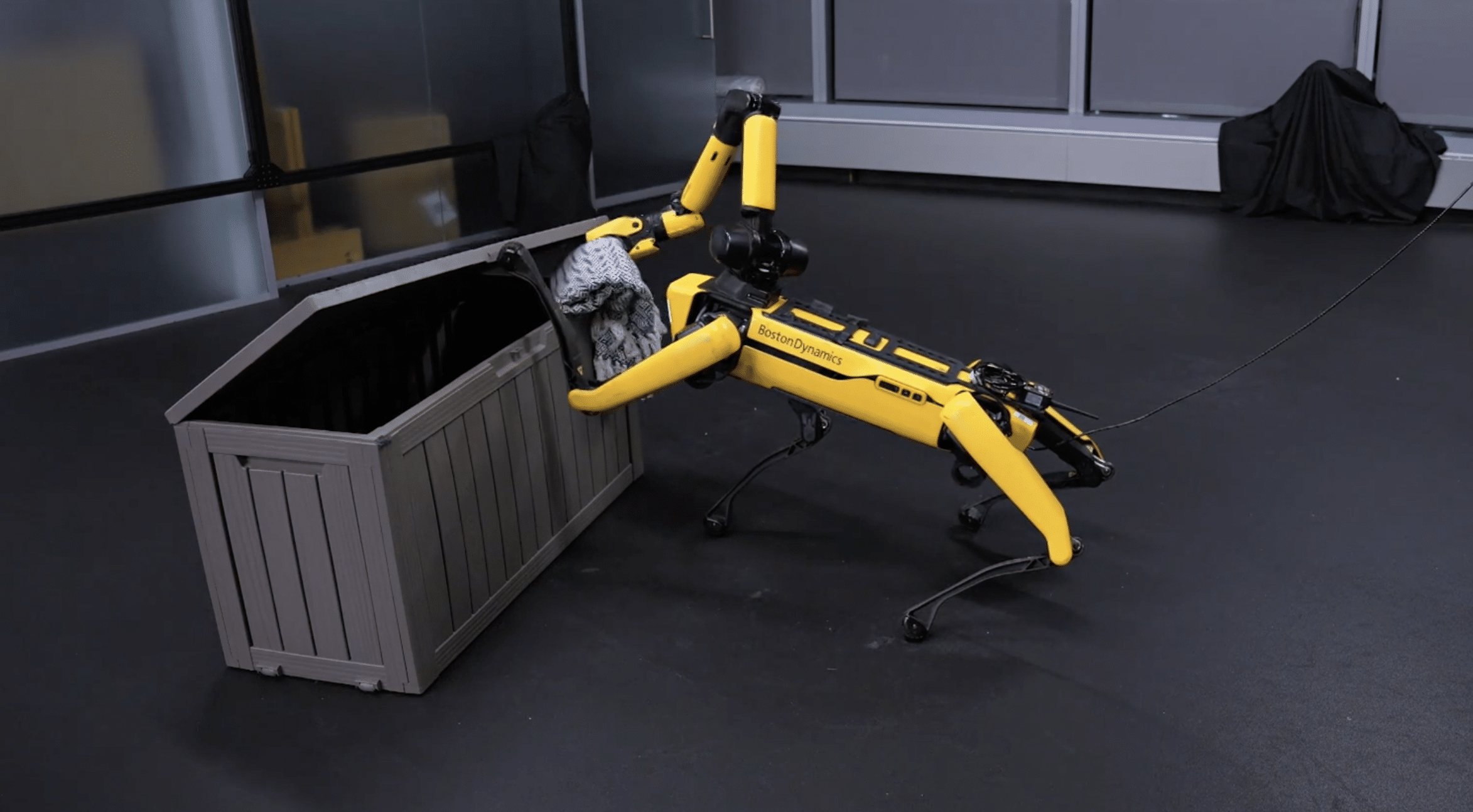 Spot quadruped robot places blanket in a deck box